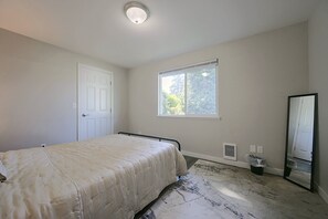 A bedroom with a bed, a window, a door, and a mirror. - Central Lacey Home: 3 Mi to Dtwn Olympia (Lacey)