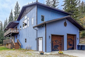 A two-story building with a balcony, a front door, and two garage doors. - Spectacular Views & Moose Sightings! Fairbanks Gem (Fairbanks)