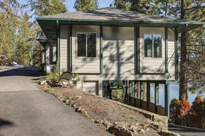 A two-story house with a dock extending into a body of water, surrounded by trees. - Dock Access, Deck & BBQ on Liberty Lake (Liberty Lake)