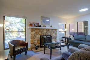 A living room with a stone fireplace, a leather chair, a sofa, and a coffee table. - Perfect Central Location - Walk to Base 9 Lifts (Breckenridge)