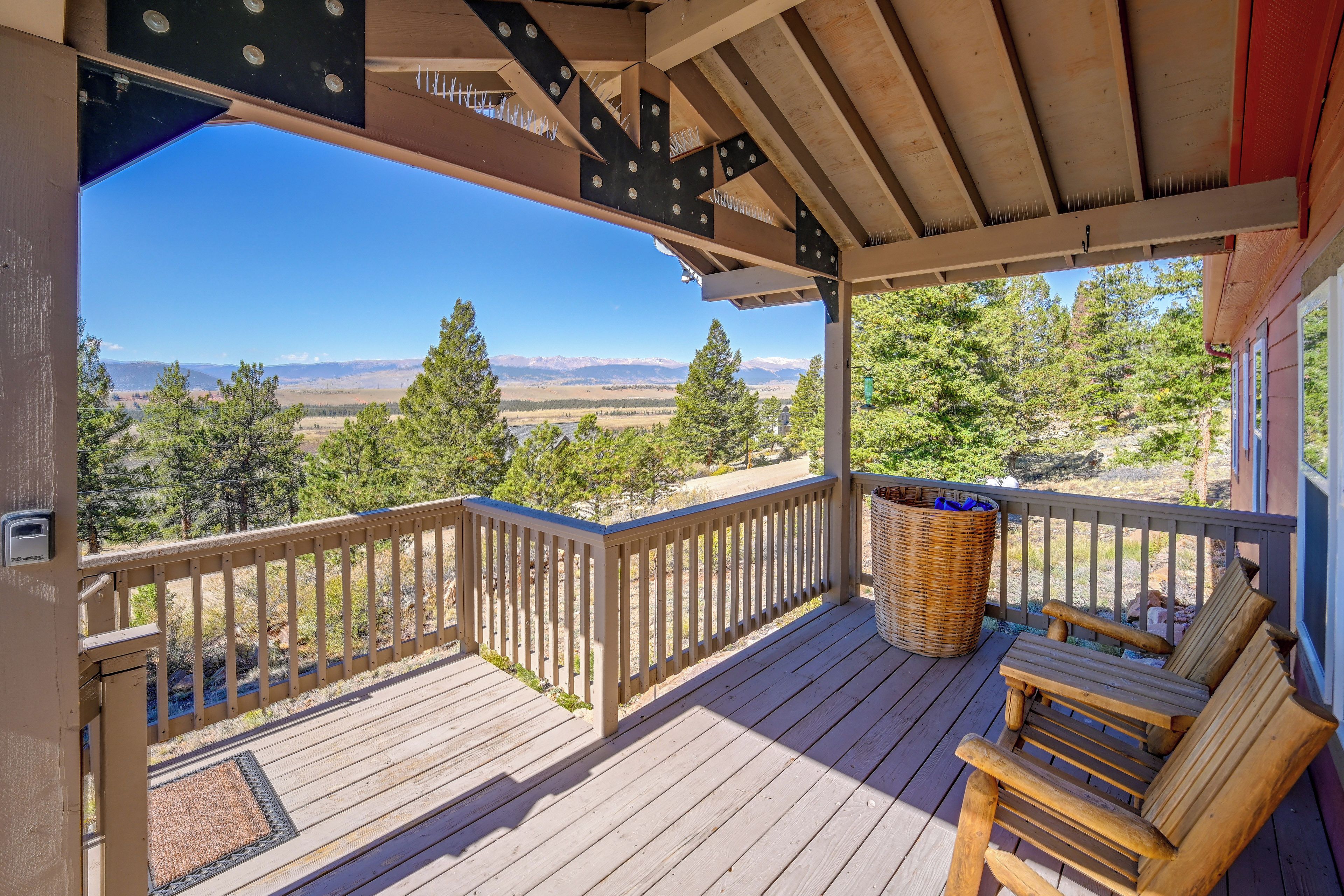 A wooden deck with a view of mountains and trees.