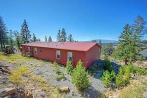 A red cabin with a metal roof, surrounded by trees and a rocky landscape. - Mtn Views & Playground - 11 Mi to Fairplay (Fairplay)