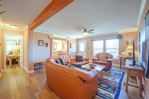 Ein geräumiges Wohnzimmer mit einer Ledersofa, einem Couchtisch und einem gemusterten Teppich.