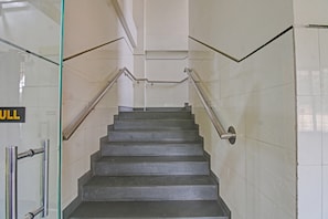 A staircase with metal handrails and a glass door with a 'FULL' sign.