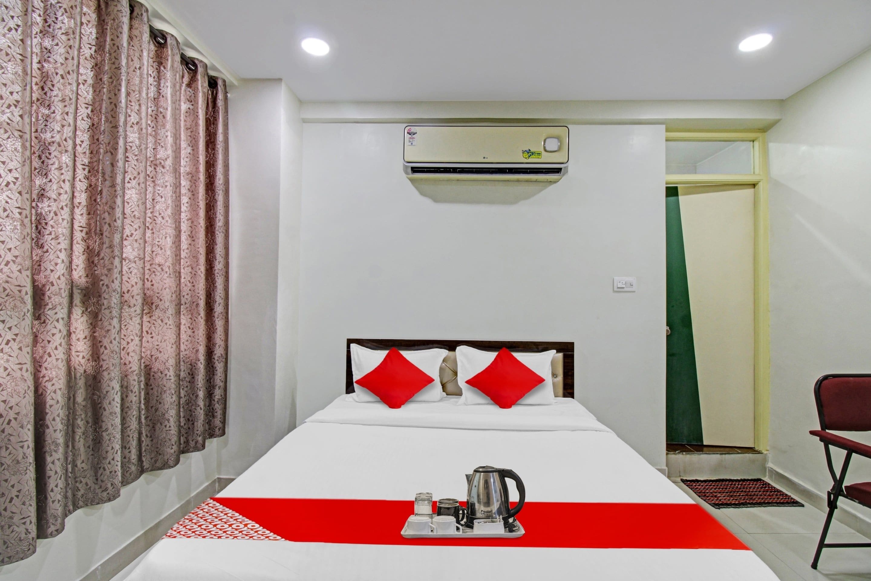 Una habitación de hotel con una cama, cafetera y aire acondicionado.