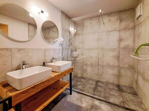 A bathroom with two white sinks, a wooden vanity, a mirror, and a shower area. - Marchegg by Interhome (Auffach)