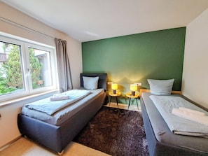 A hotel room with a bed, a sofa, a window, and a small table with a lamp. - Marchegg by Interhome (Auffach)