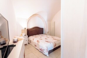 A bedroom with a bed, a desk, and a chair. - Historic stone vault in NOCI incl  breakfast (Noci)