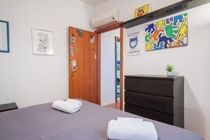 A bedroom with a bed, a dresser, and a door with stickers. - Borgo Dei Greci Loft (Firenze)