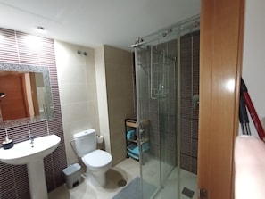 Ein Badezimmer mit Toilette, Waschbecken und einer Duschkabine.