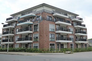 A multi-story residential building with balconies, brick facade, and a flat roof. - Holiday apartment 14 in Villa Meeresblau (Cuxhaven)