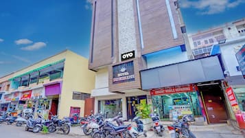 Un hôtel avec une enseigne indiquant « Hôtel Sunshine Deluxe » et une rangée de motos garées devant.