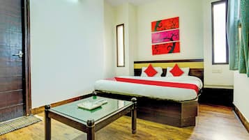 Una habitación de hotel con cama, mesita de noche, ventana y puerta.