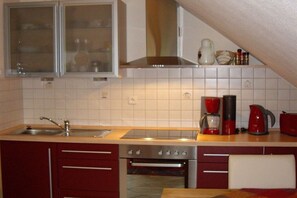 A kitchen with a sink, stove, oven, and cabinets. - Holiday apartment Höflich "Heide 1" (Bad Zwischenahn)