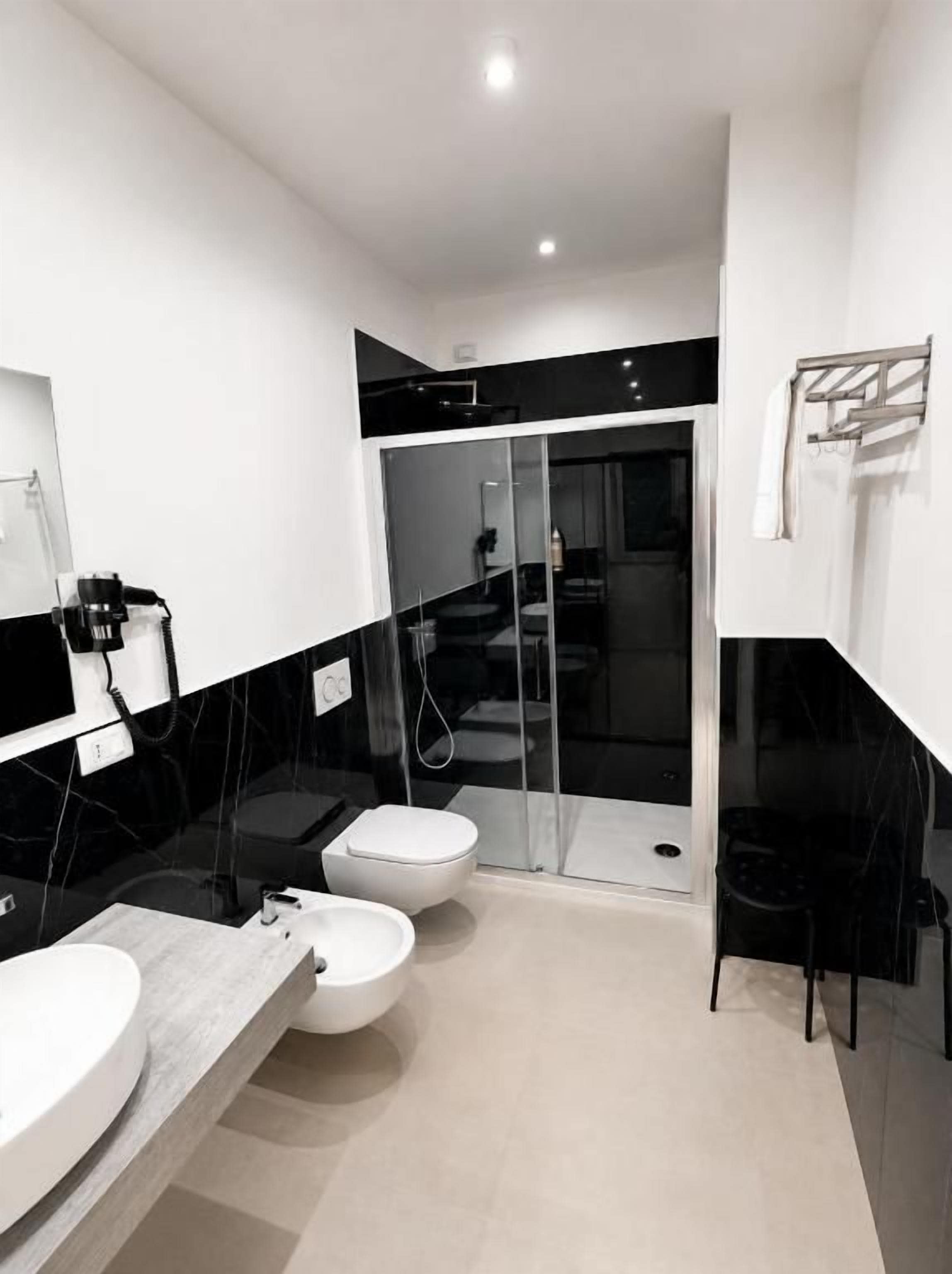 Une salle de bain moderne avec une douche à parois de verre, des toilettes et un lavabo.