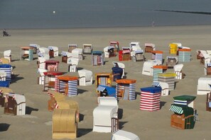 A beach with numerous beach huts arranged in rows. - Linden holiday apartment with balcony (Borkum)