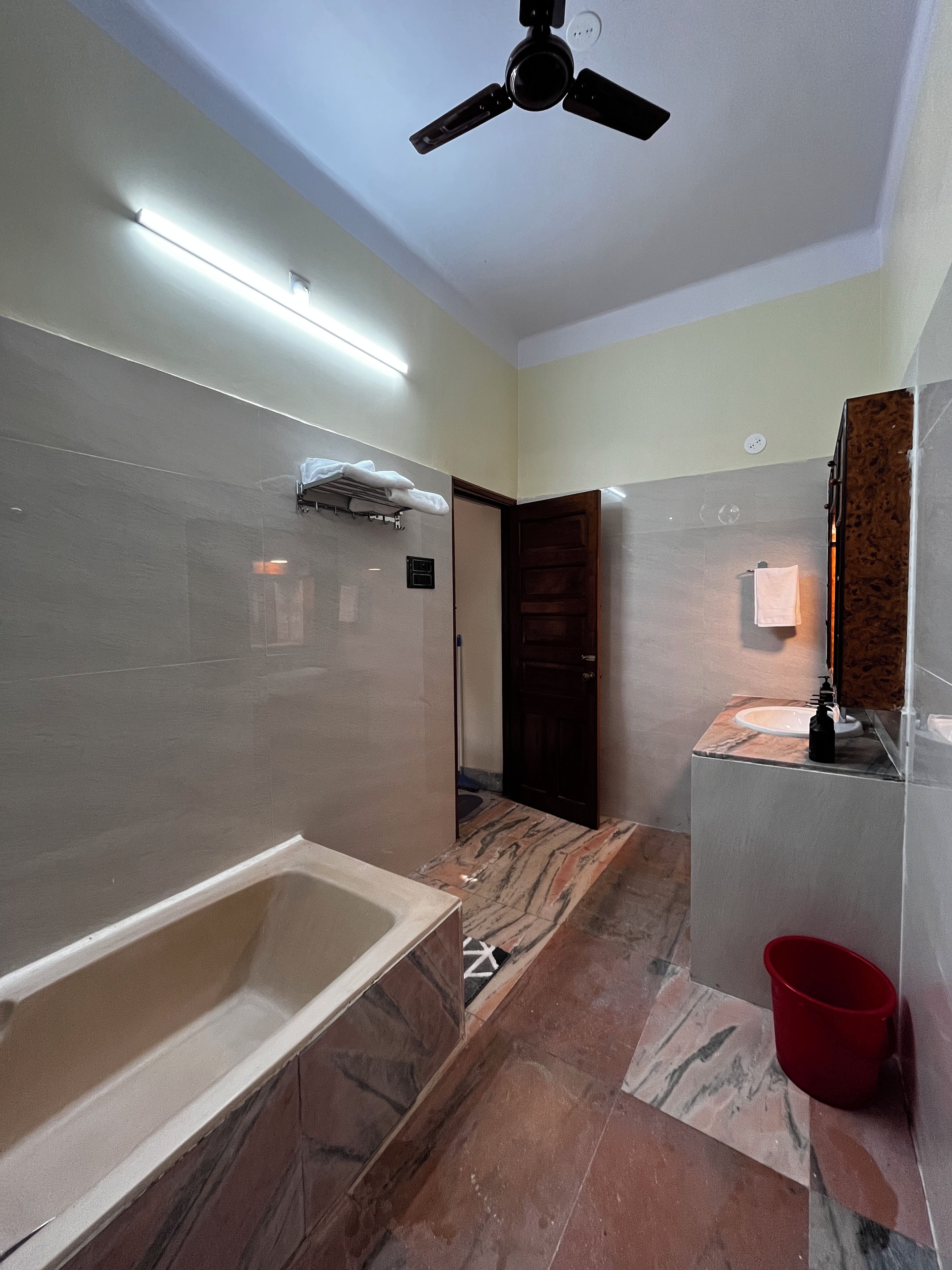 Un baño con bañera, lavamanos, espejo y ventilador de techo.