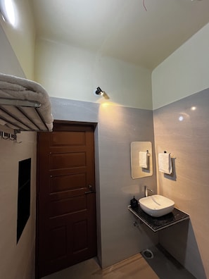 A bathroom with a wooden door, a sink, and a towel rack.