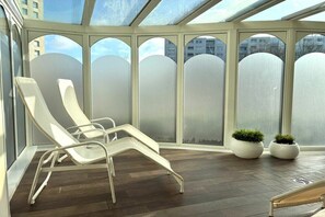 A sunlit room with a glass ceiling, two lounge chairs, and two potted plants. - Lord Nelson, 2nd floor (Cuxhaven)
