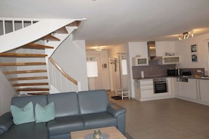 A modern kitchen with white cabinets, a microwave, and a stove. - Holiday home with 2 bedrooms (Glowe - Insel Rügen)