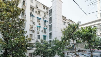 Un edificio residencial de varios pisos con balcones, unidades de aire acondicionado y una variedad de estilos de ventanas.