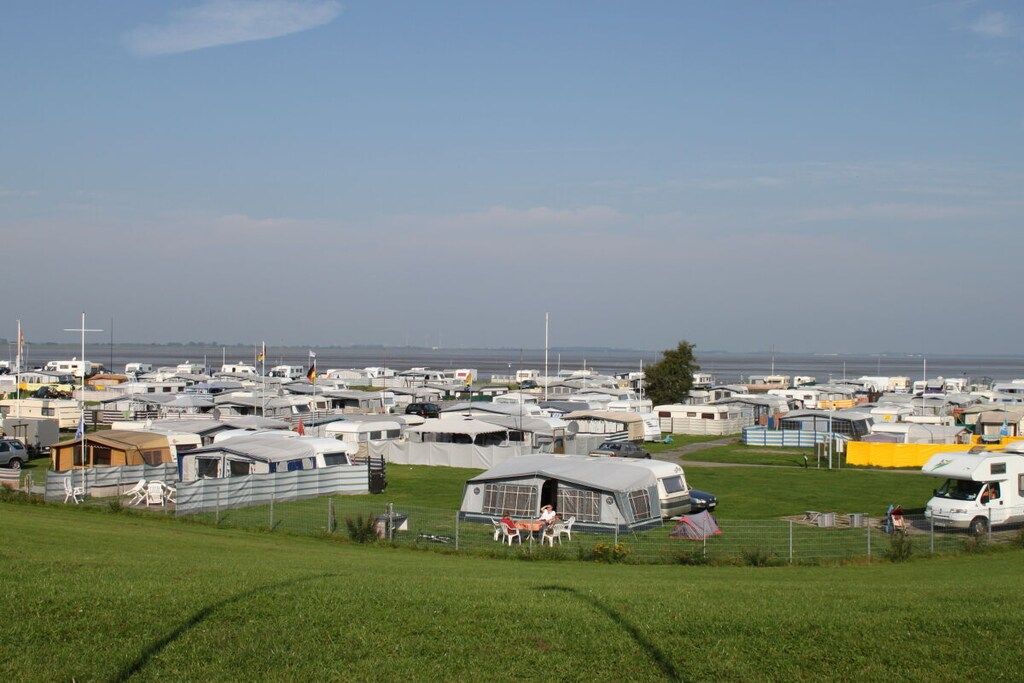 A caravan park with multiple caravans and a grassy field.