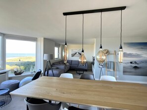 A modern living space with a dining area, a sofa, and a view of the outdoors. - Holiday Home in Cadzand With Swimming Pool (Cadzand-Bad)