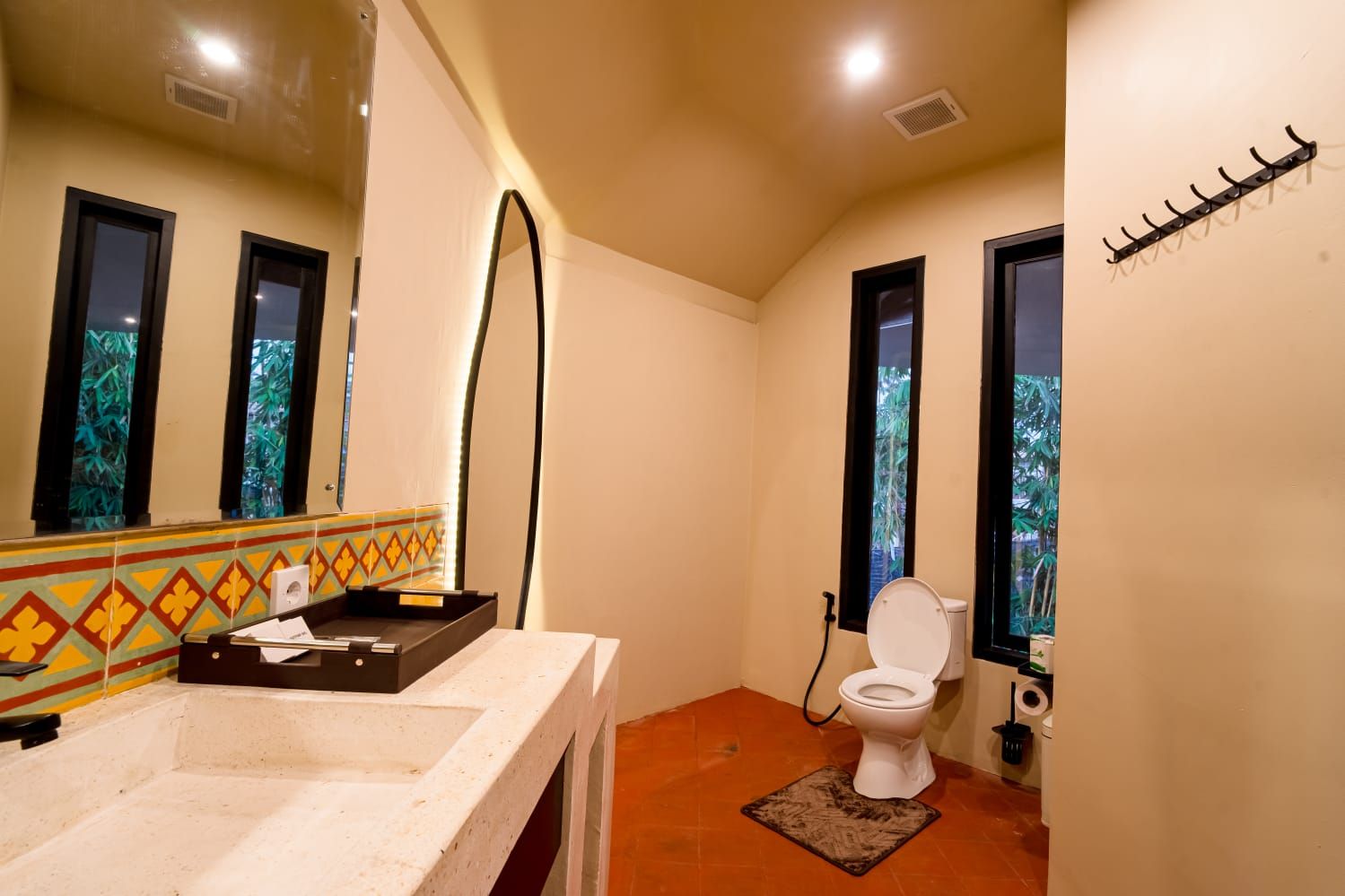 A bathroom with a sink, toilet, and a mirror.