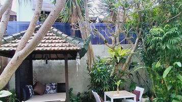 A pool area with a covered seating area and a small table.