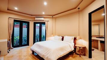 A hotel room with a large bed, a bedside table, a mirror, and a view of the outside.