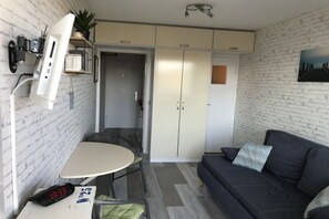 A compact living space with a kitchenette, a dining area, and a seating area. - Dünenhof zum Kronprinz (Wenningstedt)
