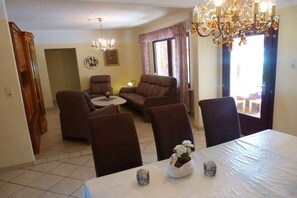 A dining area with a table, chairs, and a chandelier. - Holiday home in Detern with swimming pool (Detern)