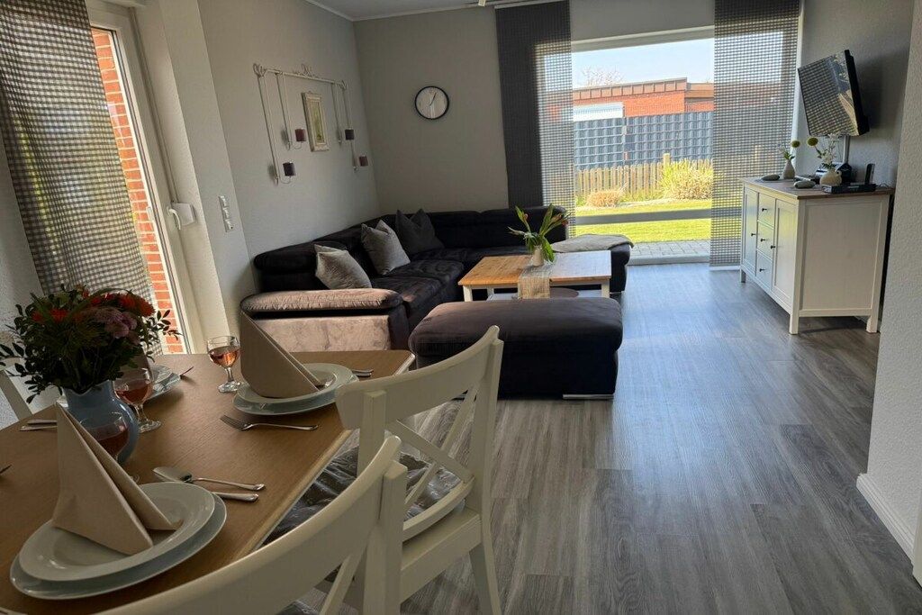 Ein modernes Wohnzimmer mit Sofa, Couchtisch und Essbereich.