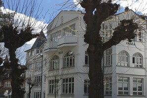 A multi-story building with arched windows and balconies, labeled 'FRIGGA.' - Holiday apartment in Binz with swimming pool (Binz)