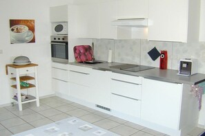 Eine moderne Küche mit weißen Schränken, einer Mikrowelle, einem Backofen und einem Toaster.