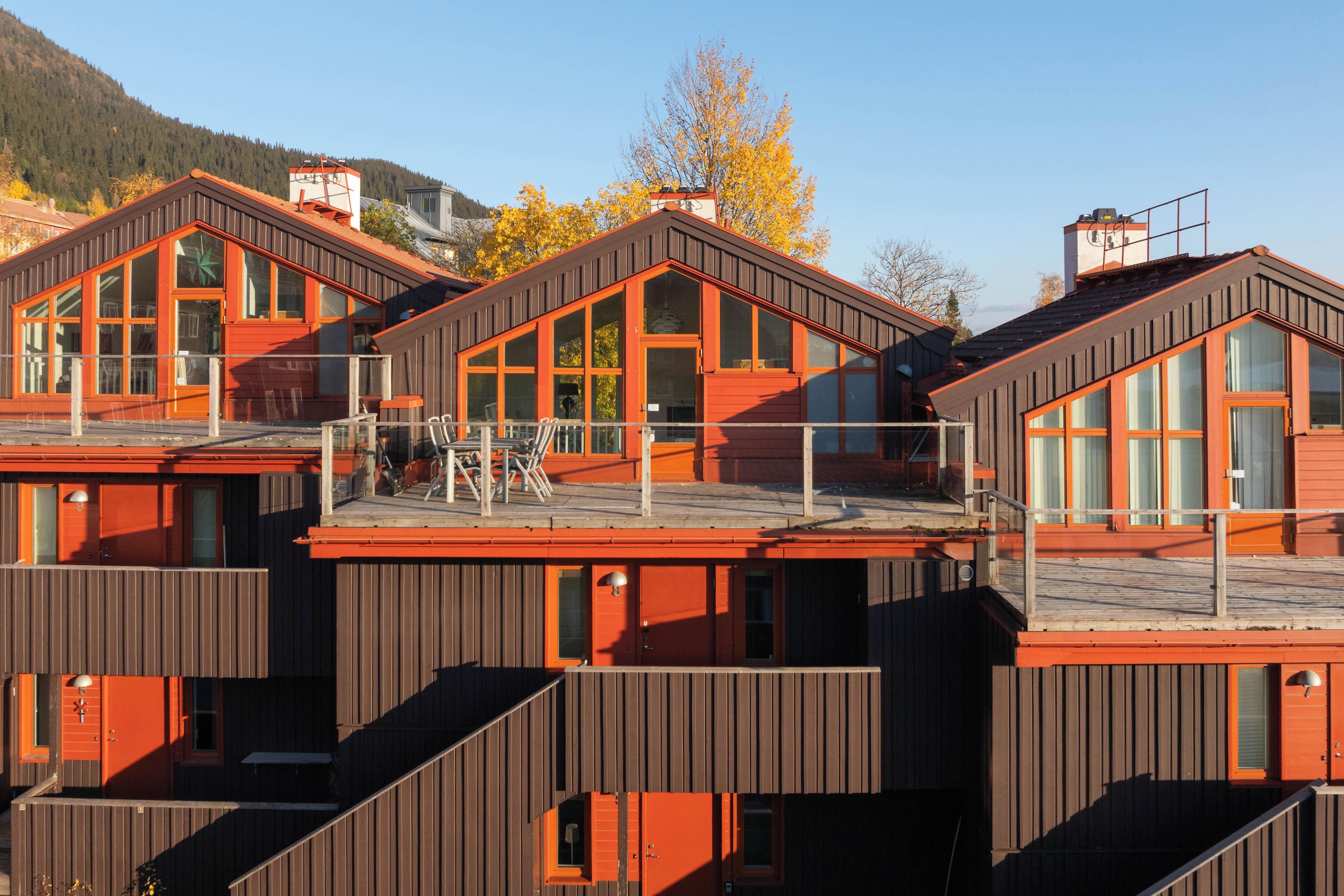 A modern multi-story building with large windows and a wooden facade.