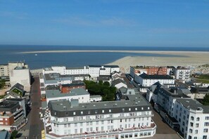 A coastal town with a beach, buildings, and a clear sky. - Holiday apartment with 2 bedrooms (Borkum)