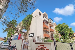 A multi-story building with a prominent 'OYO' sign, a gated entrance, and a motorcycle parked in front. - Hotel O Moonlight Inn (Nagpur)