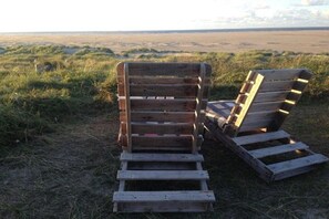 Two wooden benches in a grassy field with a view of the horizon. - 1 in the Vogelkieker House (Borkum)