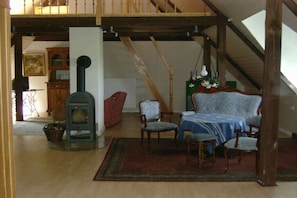 A room with a fireplace, wooden furniture, and a staircase. - Holiday home in Büschow with swimming pool (Büschow)