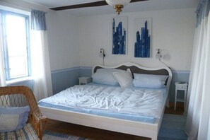A bedroom with a bed, a chair, and two wall-mounted nightstands. - Holiday home in Büschow with swimming pool (Büschow)