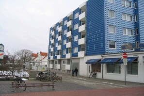 A multi-story building with a distinctive blue and white facade, featuring balconies and a ground-level entrance. - Neptune House Iderhoff Norderney (Norderney)