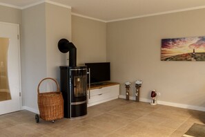 Ein Wohnzimmer mit Kamin, Fernseher und einem Gemälde an der Wand.
