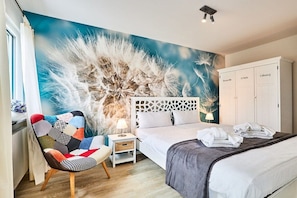 A bedroom with a bed, a nightstand, a chair, and a wardrobe. - Holiday apartment in Hörnum with Wi-Fi (Hörnum)
