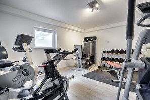 A gym with exercise equipment, a treadmill, and a weight bench. - Holiday apartment in Hörnum with Wi-Fi (Hörnum)