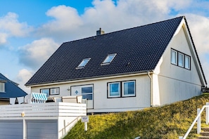 A two-story house with a dark roof, multiple windows, and a white exterior. - Holiday apartment in Hörnum with Wi-Fi (Hörnum)
