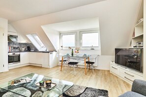 Ein modernes Apartment mit Küche, Essbereich und Wohnbereich.