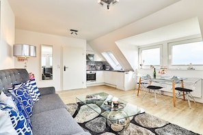 Eine moderne Wohnung mit Wohnzimmer, Essbereich und Küche.