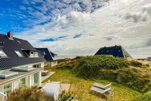 A coastal property with modern architecture, including a house with a sloped roof and a separate building with a flat roof. - Holiday apartment in Hörnum with Wi-Fi (Hörnum)