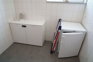 A small, clean bathroom with a white sink, a mirror, and a toilet. - Küsters holiday apartment "Tina" (Hinte)